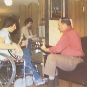 pat harris-banjo a man in a wheelchair, Pat Harris, plays a banjo. the photo is from the 1970s